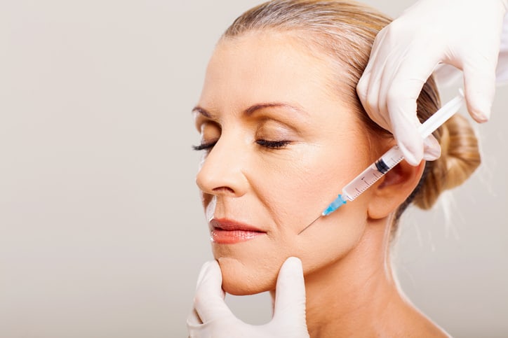senior woman doing face lifting on her cheek