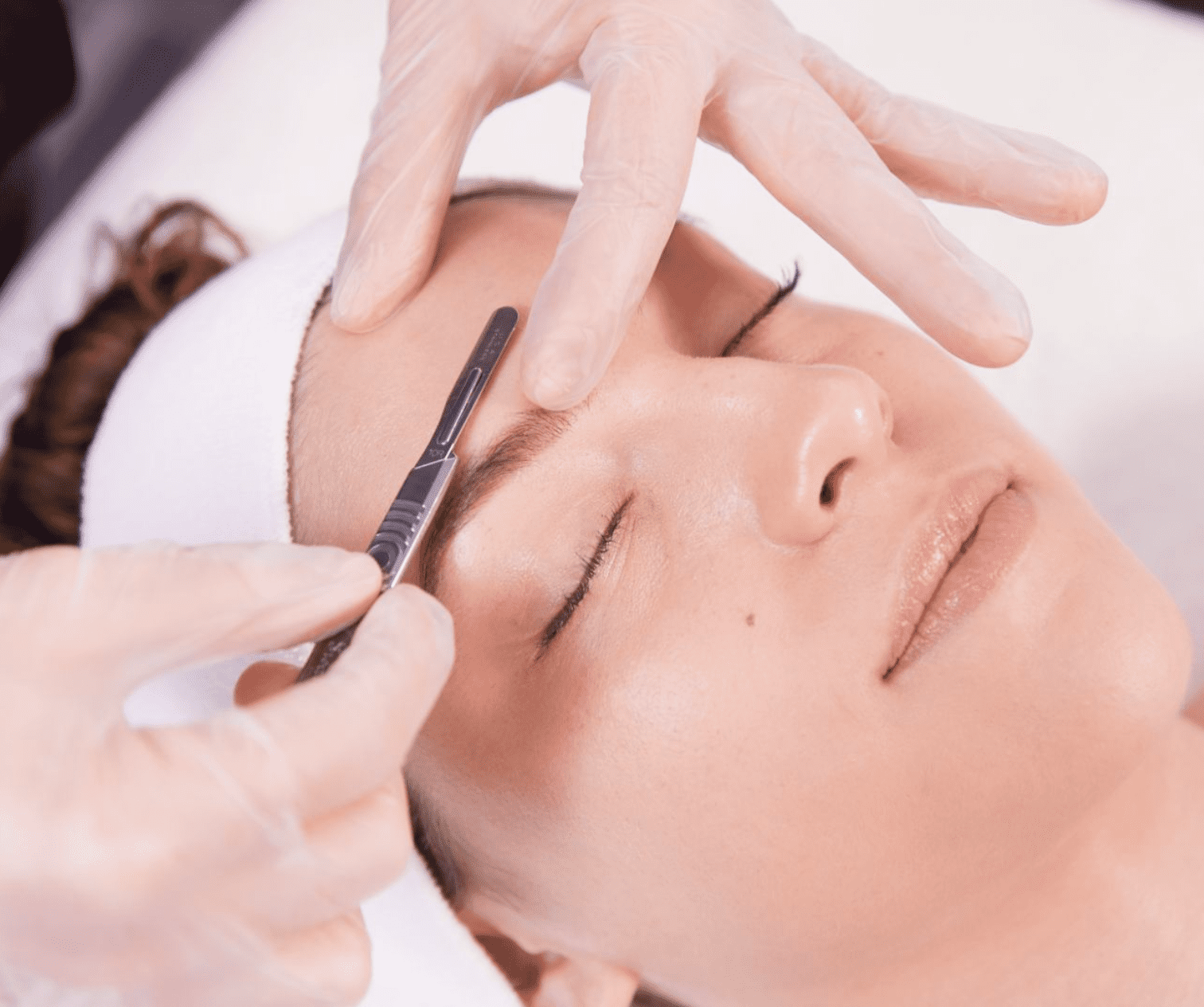 Dermaplaning being performed on a woman