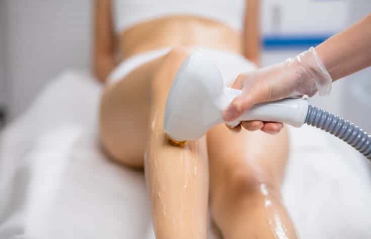 Laser hair removal service being performed on a client's legs