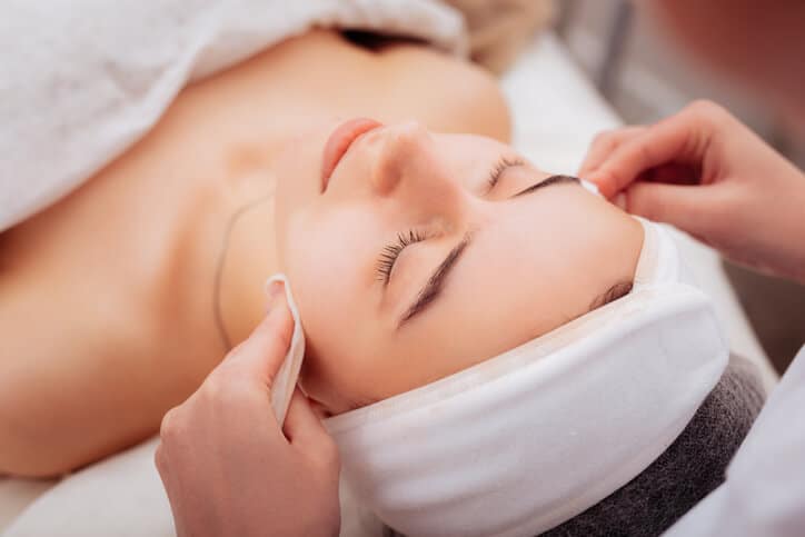 Spa Therapist giving a client a relaxing facial massage.