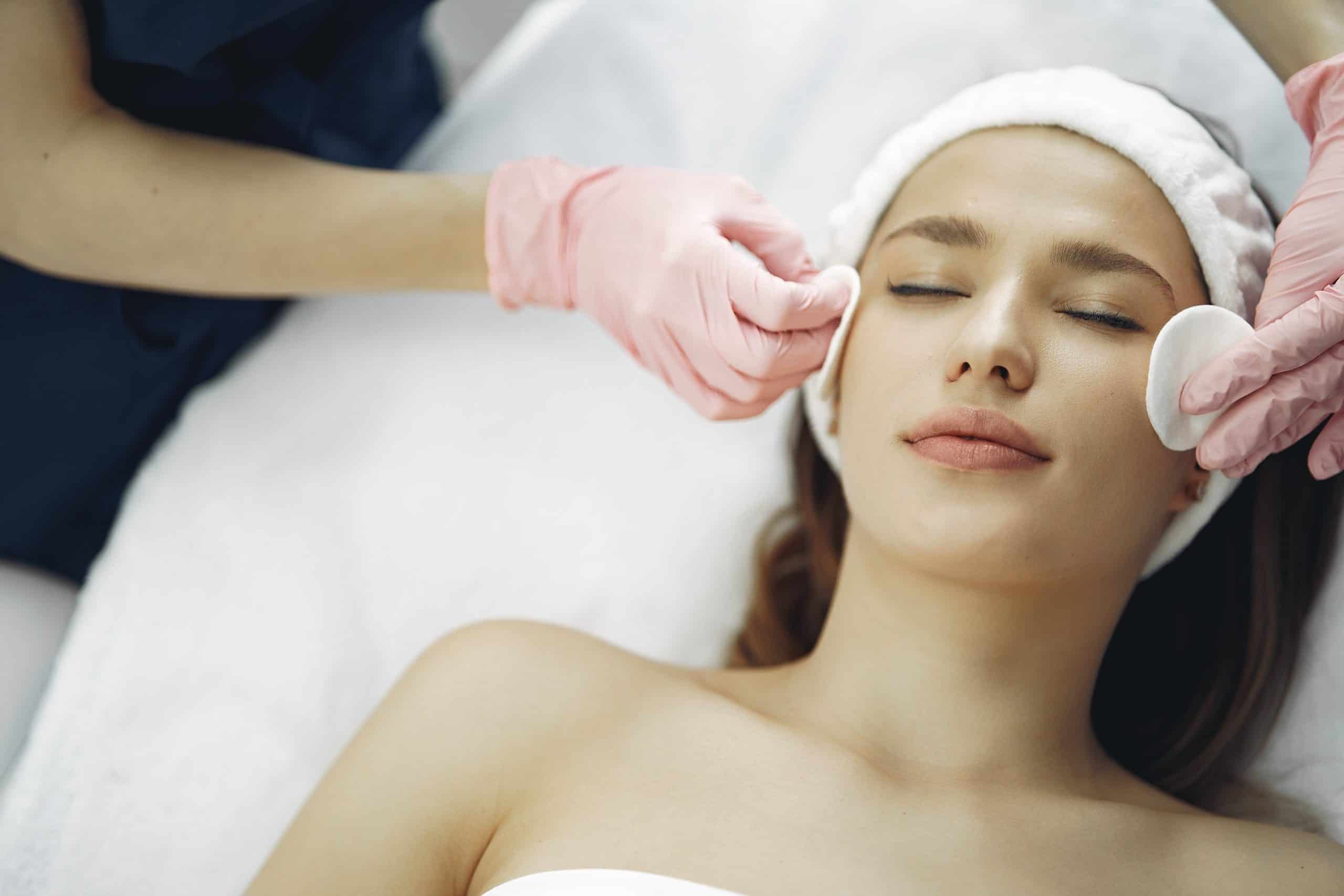 Woman receiving a facial from an esthetics professional.
